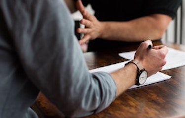 Two People Conversing And Filling Out A Form