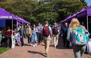 Students Walking Nearby Several Canopies on Campus